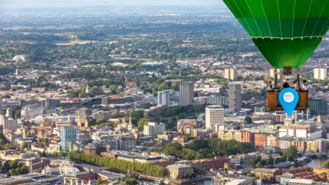 Bristol International Balloon Fiesta Image of people in a hot air balloon. Bristol can be seen below