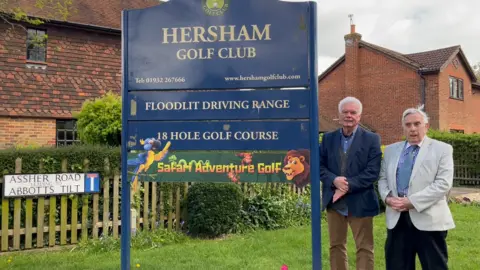 BBC/Julia Gregory A Hersham Golf Club sign next to which are standing Roy Green and Stephen Foster