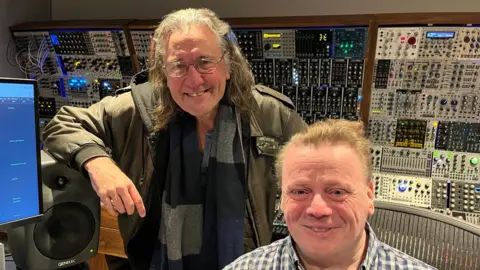 Dave Griffiths and Lester Barnes with lot's of musical equipment in Lester's home recording studio at the bottom of his garden.