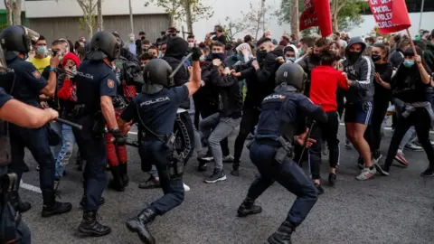 EPA Police officers confront protesters next to the South Station, in Madrid, during a protest against coronavirus restrictions