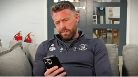 Luton Town Luton Town manager Rob Edwards looking at a mobile phone
