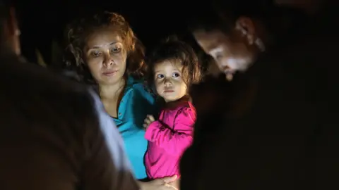 Getty Images A two-year-old Honduran girl as her mother is searched and detained near the US-Mexico border on in McAllen, Texas, on 12 June 2018