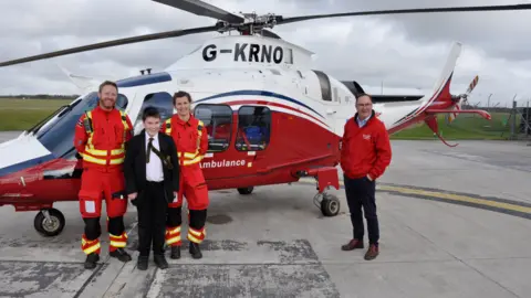 Cornwall Air Ambulance Finlay in front of the air ambulance with paramedics