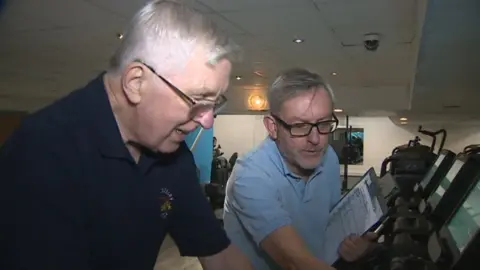 BBC Man on treadmill with gym instructor