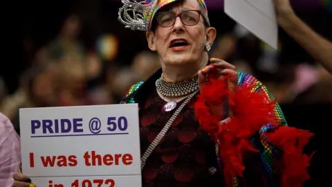 EPA A person holding a sign which reads 'Pride @50 I was there in 1972'