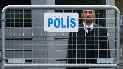 Getty Images An official stands behind police barriers at the Saudi consulate in Istanbul, Turkey, 21 October 2018