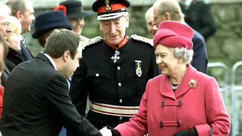 PA Media Queen Elizabeth II arrives in Londonderry, Northern Ireland for the first time in half a century, Thursday 15 November, 2001, and is greeted at the Maydown Ebrington Centre by the Social Development Minister, Nigel Dodds.