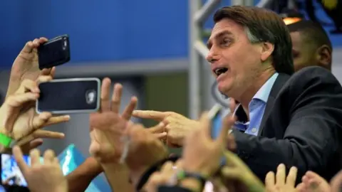 AFP Jair Bolsonaro is greeted by supporters in Rio de Janeiro, Brazil. Photo: 22 July 2018