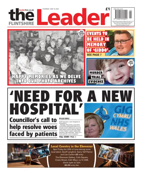 Flintshire Leader Front page of the Flintshire Leader with the main headline 'Need for a new hospital' with a composite image of blue NHS Wales Uniform with a headshot of the councillor. There is a sub headline underneath which reads 'Councillor's call to help resolve woes faced by patients'. Other headlines read 'Murder trial evidence', 'Events to be held in memory of 'giddo'', 'Happy memories as we delve into our photo archives', with a black and white image of a group of children.