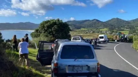 Getty Images People wait on higher ground on Great Barrier Island, New Zealand