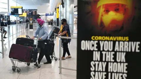 EPA Passengers wear masks as they arrive at Heathrow Airport, in Britain