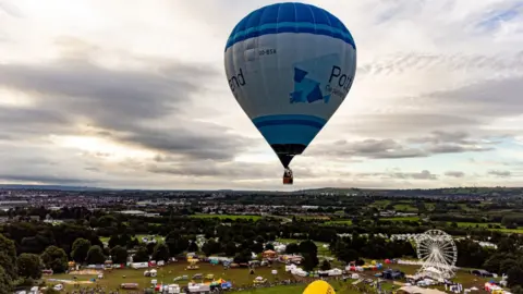 Ben Birchall/PA Wire A blue hot air balloon in the sky