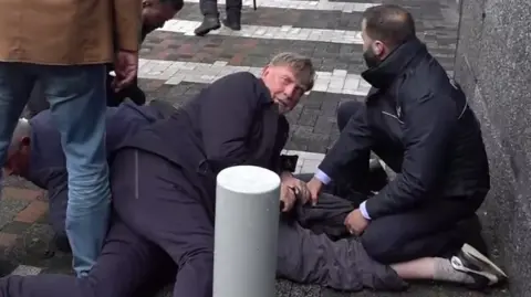 Security pinning down a protester