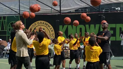 BBC/Kyla Herrmannsen Harry plays basketball with school students