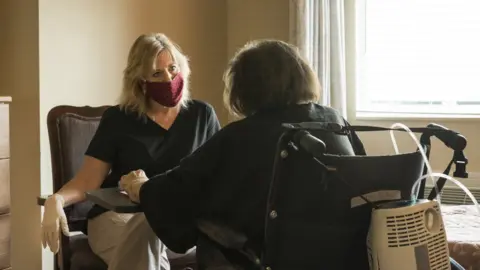 Getty Images Someone making a visit in a care home