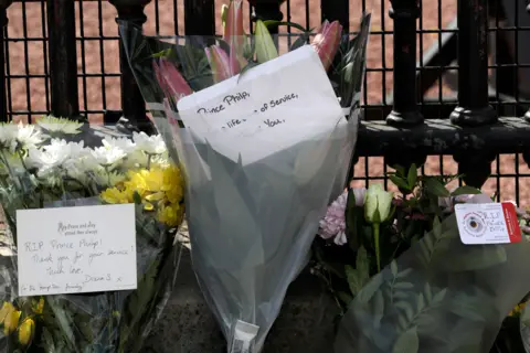 Getty Images Floral tributes are seen at Buckingham Palace