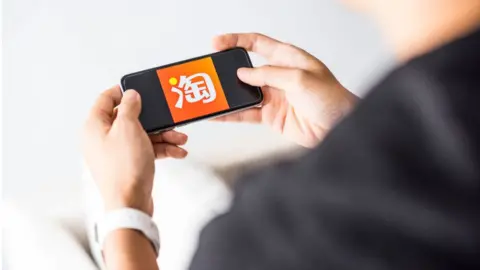 Getty Images Man using Taobao app on Apple iPhone