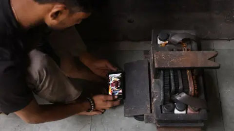 Getty Images Representational image - A man in Delhi watches a movie on his smartphone