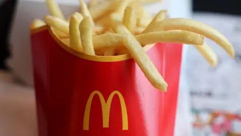 Getty Images A red paper cup with the McDonald's golden arches on, filled with fries