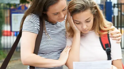 Getty Images A girl and her mum look sad about her results