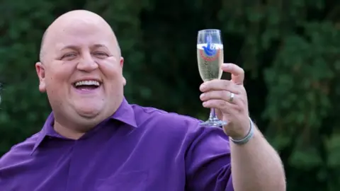 Adrian Bayford celebrates his lottery win