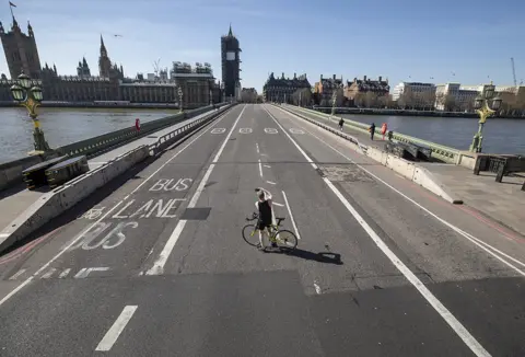 Peter Macdiarmid/LNP A cyclist stops in the middle of an almost deserted Westminster Bridge