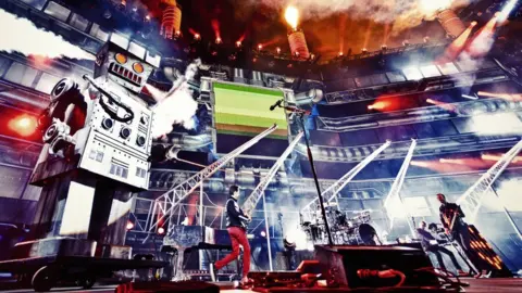 Hans Peter Van Velthoven Muse performing in front of Cirque Bijou's Charles the Robot