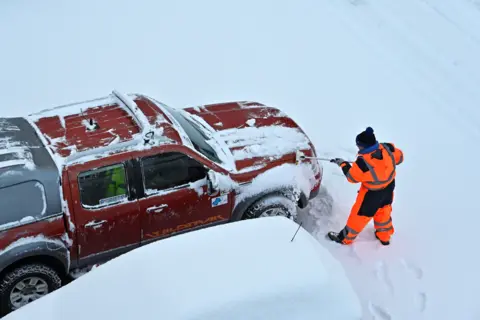 Getty Images A man clears snow from his truck in a car park in Dalgety Bay, Fife, on 9 February 2021