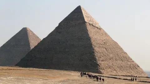 EPA Tourists visit the pyramids on the Giza plateau, Egypt (2 February 2023)