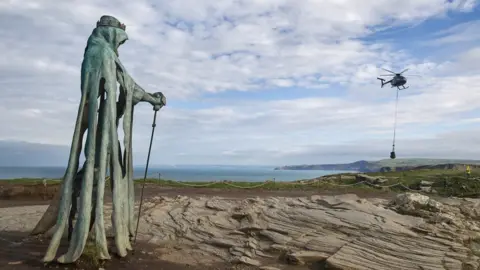 Tintagel Castle's statue 'Gallos', and the helicopter