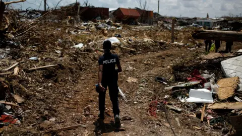 Reuters A police officer searches for the dead in the Abaco Islands