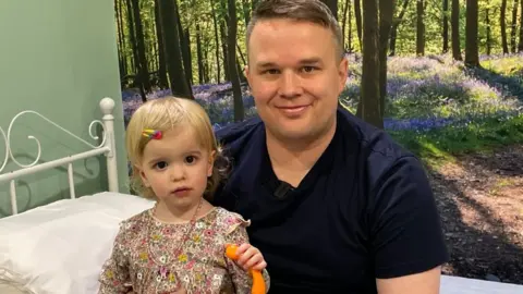 Kate Bradbrook/BBC Chloe pictured in a dress standing beside her father in the hospital's new bedroom