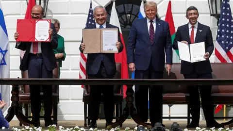 Reuters Bahraini Foreign Minister Abdullatif bin Rashid Al-Zayani, Israeli Prime Minister Benjamin Netanyahu and United Arab Emirates Foreign Minister Sheikh Abdullah bin Zayed display their copies of the Abraham Accords as US President Donald Trump looks on, at a ceremony at the White House (15 September 2020)