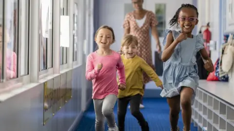 Getty Images Pre-school children running through a hallway