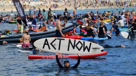 PA Media Protesters take part in a paddle out, organised by Surfers Against Sewage, on Gyllyngvase Beach near Falmouth, during the G7 summit in Cornwall.