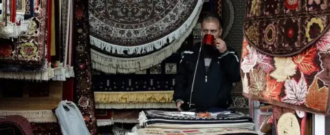 EPA An Iranian shopkeeper at a stand in a market in Tehran, Iran, 5 November 2018