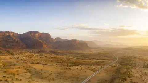 Getty Images Sunset lit the empty road crossing the dry land of Gheralta Mountains, aerial view, Hawzen, Tigray Region, Ethiopia