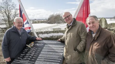 BBC North Yorkshire County Councillor Peter Sowray, chairman of the War Memorial Committee Nigel Denison, and Roger Clements of Brafferton Parish Council with the new memorial