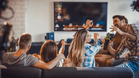 Getty Images Gang of friends watching TV