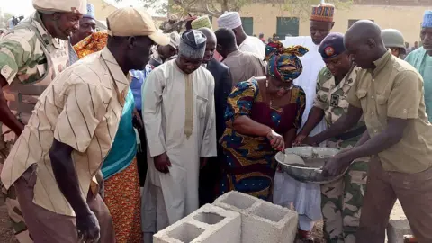 Getty Images Ngozi Okonjo-Iweala lays foundation of new classrooms for a school in Chibok burnt down by Boko Haram fighters - 2015