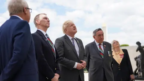 PA Media Prime Minister Boris Johnson (centre) looks at names of British personnel who lost their lives in the Falklands War at the Armed Forces Memorial at the National Memorial Arboretum in Alrewas, Staffordshire before a service to mark the 40th anniversary of the liberation of the Falkland Islands.