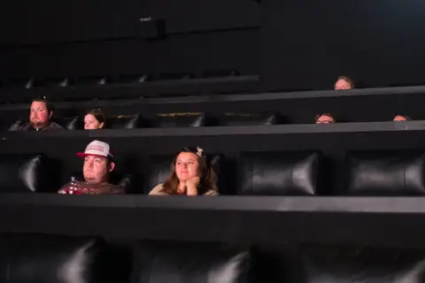 PA Media People sit in a cinema