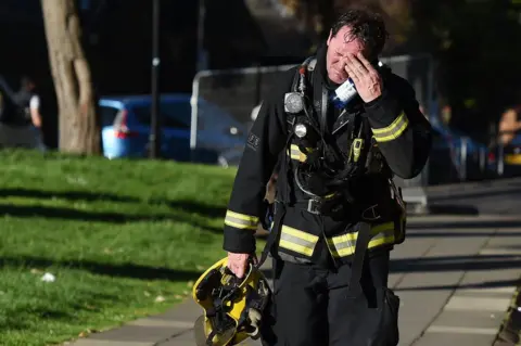 EPA A firemen reacts after battling the huge fire at the Grenfell Tower