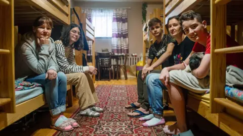 POLLY BRADEN Aliesia with her mum, Maryna, brother Tymofii, cousin, Oleksandr and aunt, Viktoriia, sharing a room in Krakow