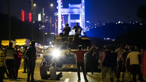 Getty Images Turks take over a tank near the Fatih Sultan Mehmet bridge in Istanbul on July 16