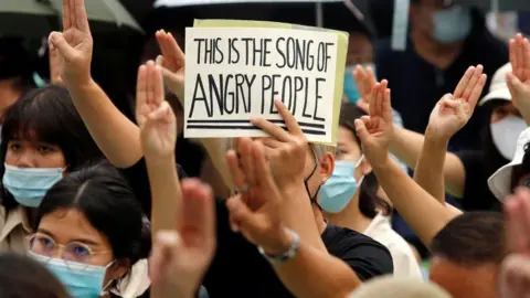 Reuters A protester holds a sign while doing a three-fingered salute during a demonstration to demand the release of activist leaders in Bangkok, Thailand August 8, 2020