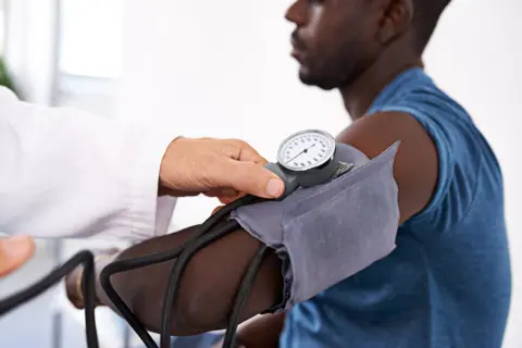Getty Images young black man having blood pressure taken