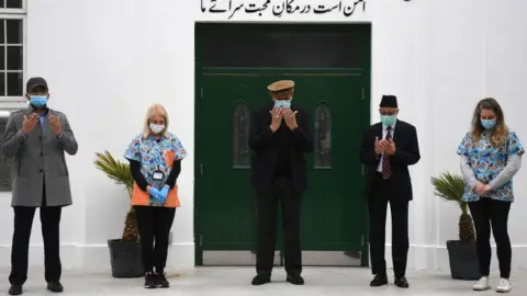 Getty Images Health workers and faith leaders at the Fazl mosque vaccination centre take part in a minutes silence