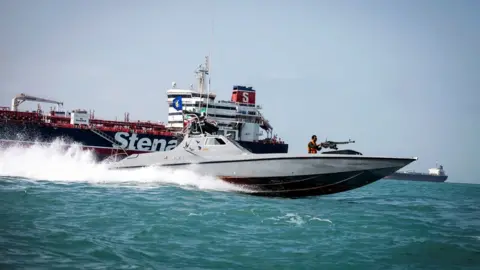 Reuters File photo showing Iranian Revolutionary Guards speedboat passing by the Stena Impero (22 August 2019)