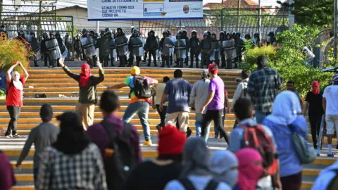 AFP Students of the National Autonomous University of Honduras confront riot police during a protest